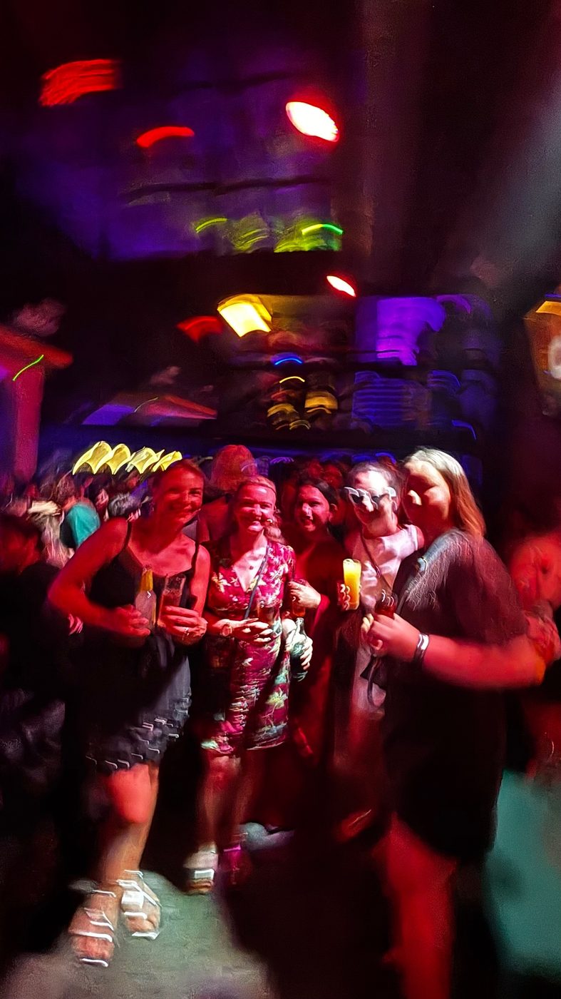 Friends dancing at a club night with coloured lights